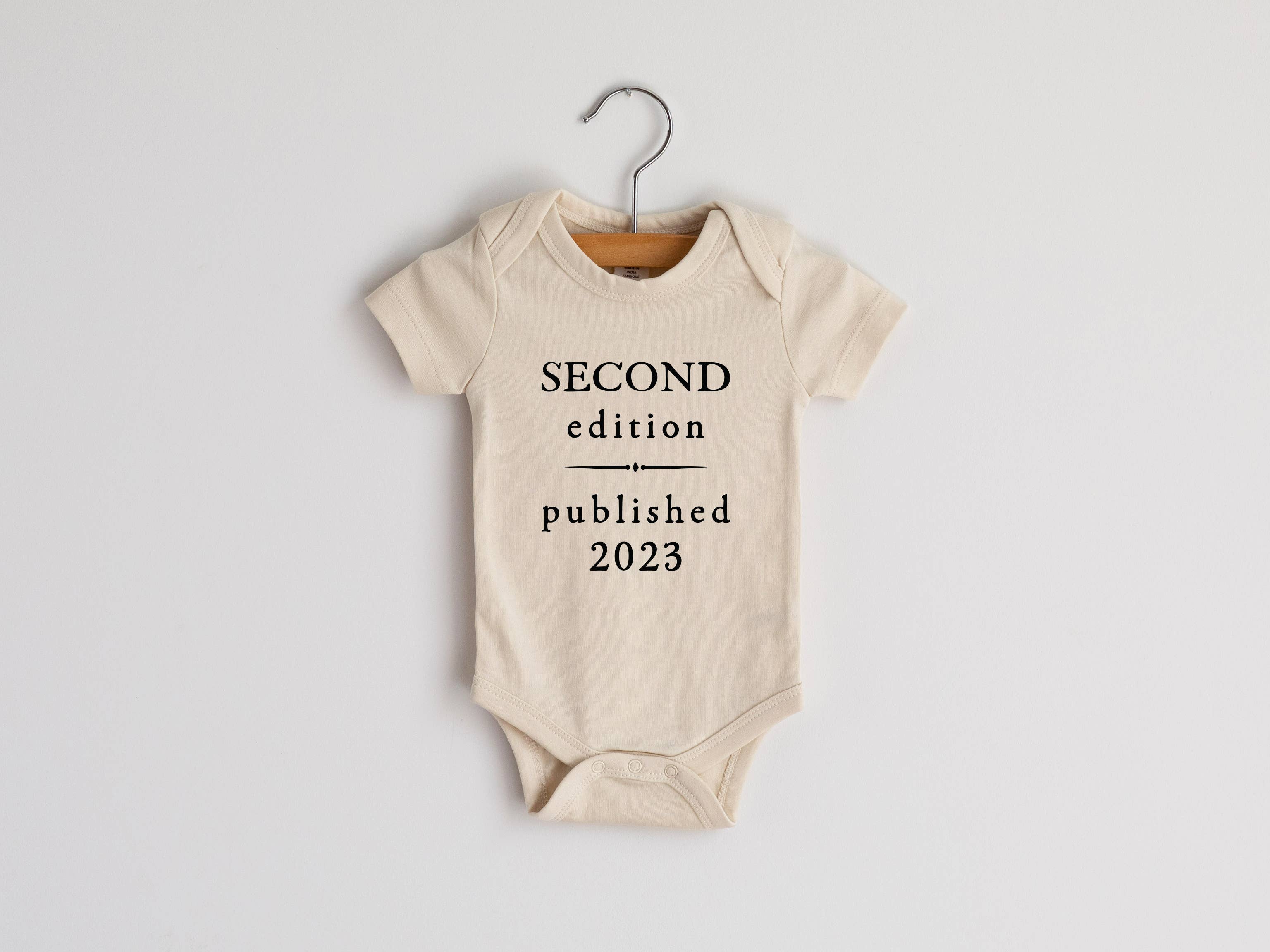Second Edition Published 2023 Organic Baby Bodysuit in Cream